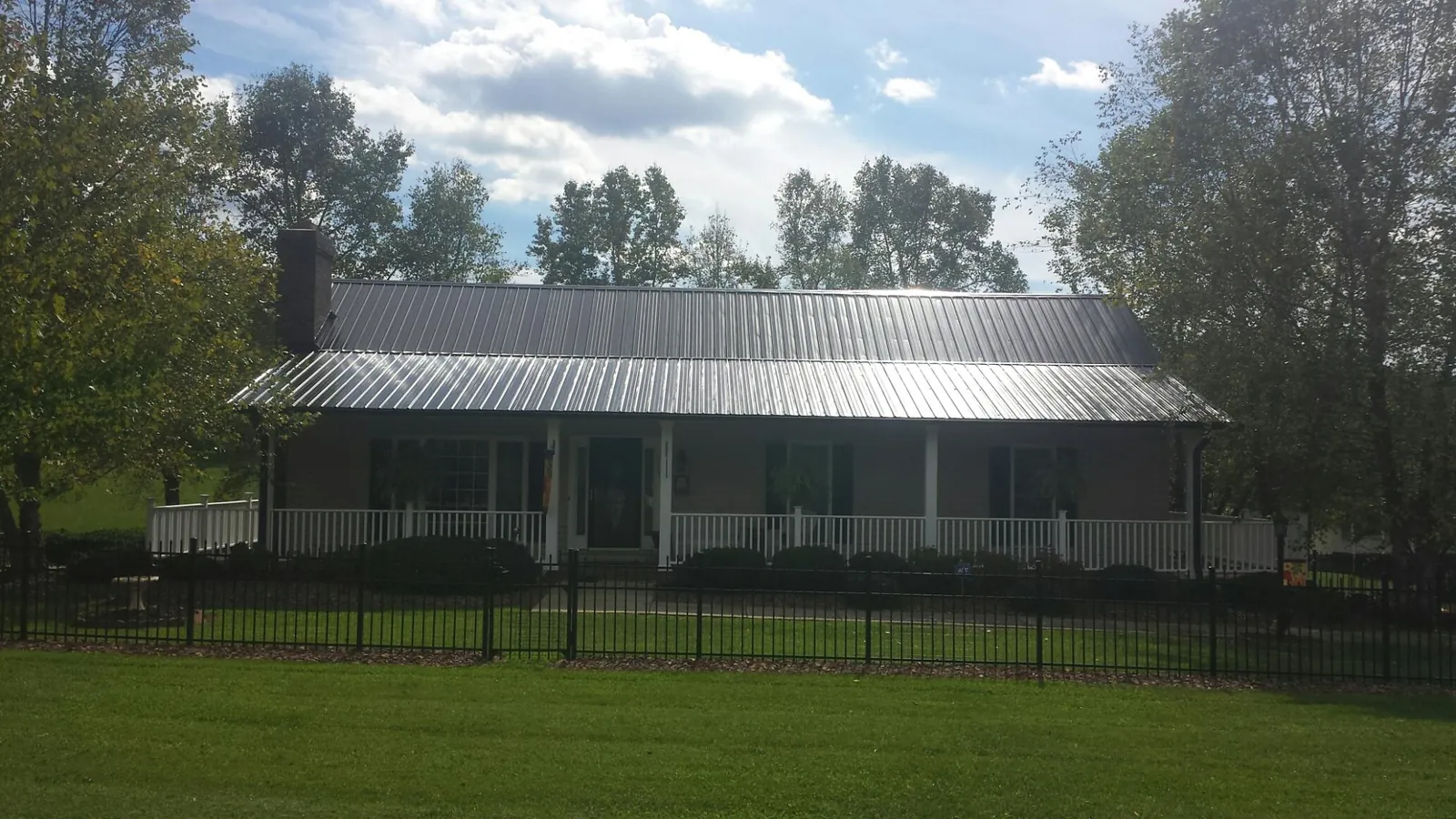 Gray metal roof on a brick ranch with a full width front porch — Gutter Guard Installation work by our crew in Sherwood